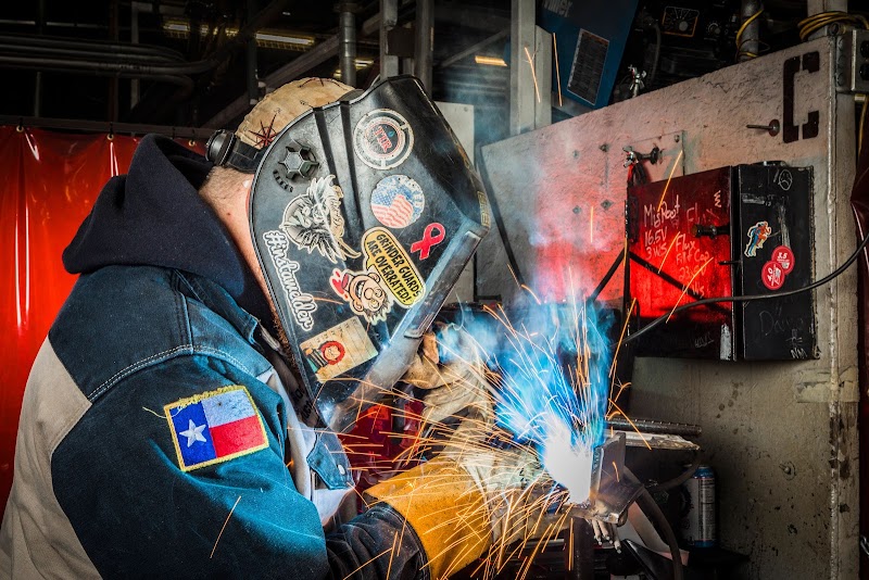 Welding instructor demonstrating techniques to students